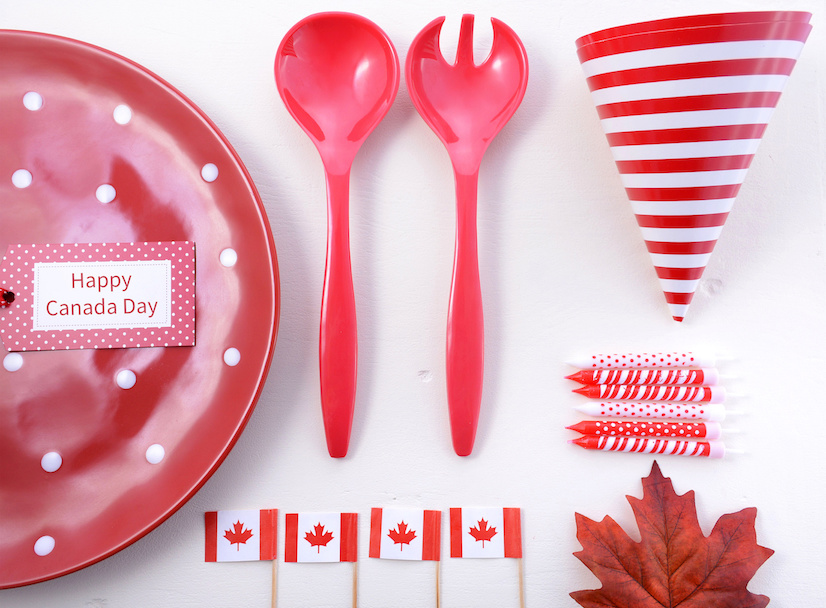 Canada Party Table Background with red and white plates, Canadian flags, and maple leaf decorations.