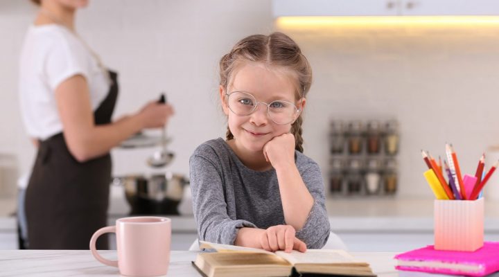 Nutrition Learning Ideas for parents. A girl doing home work at kitchen island while mother is cooking.