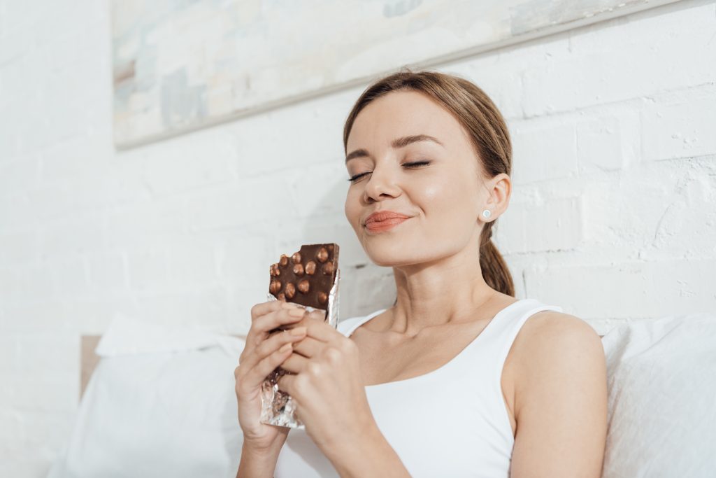A woman enjoying a large chocolate bar