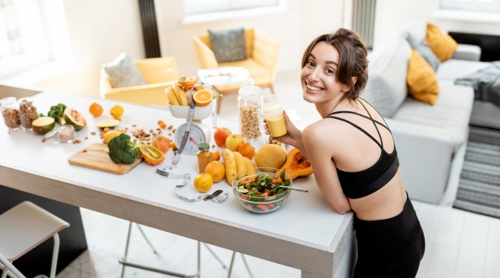 A woman in the kitchen with healthy foods on kitchen island