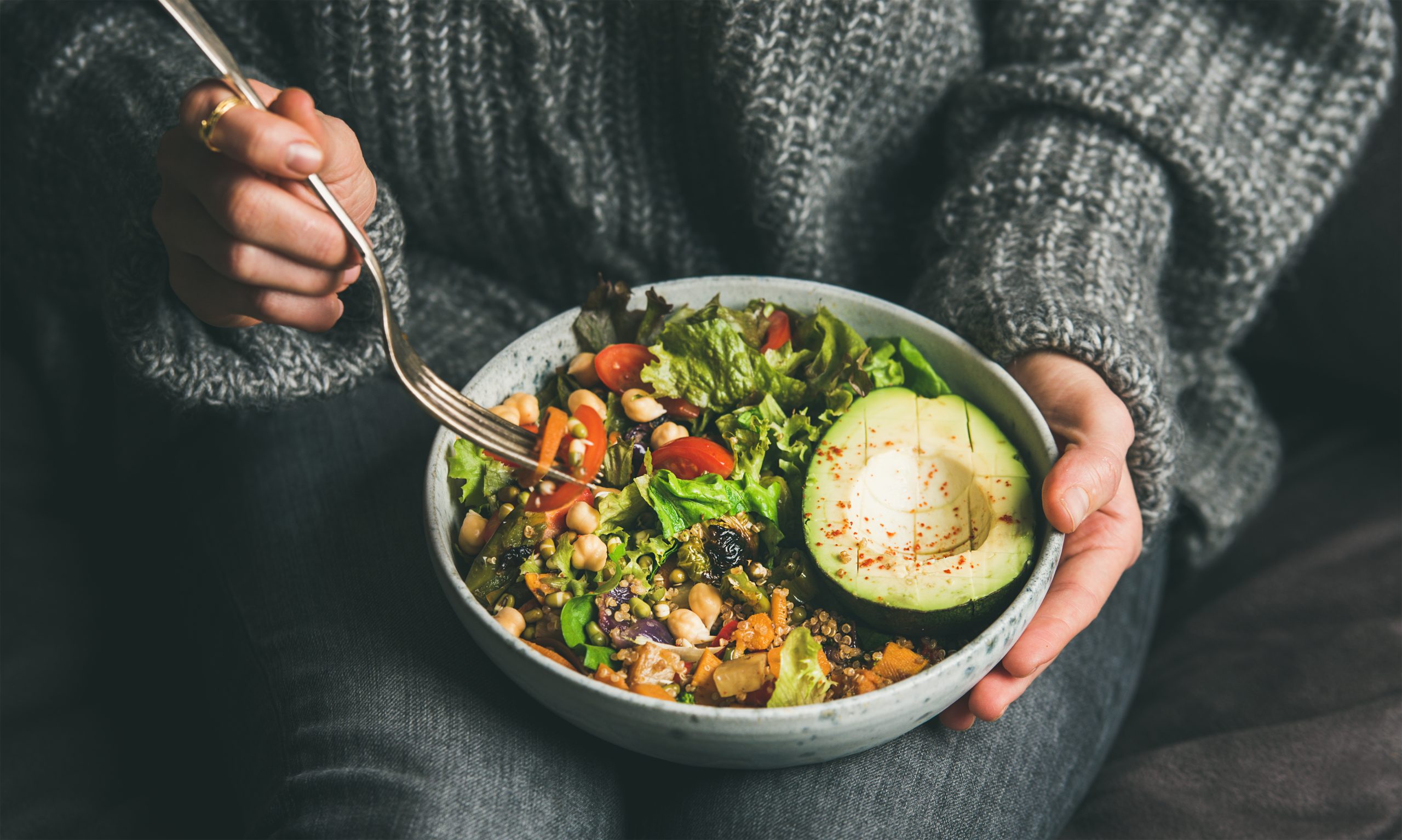 Woman eating healthy vegetarian dinner from Buddha bowl, close-up