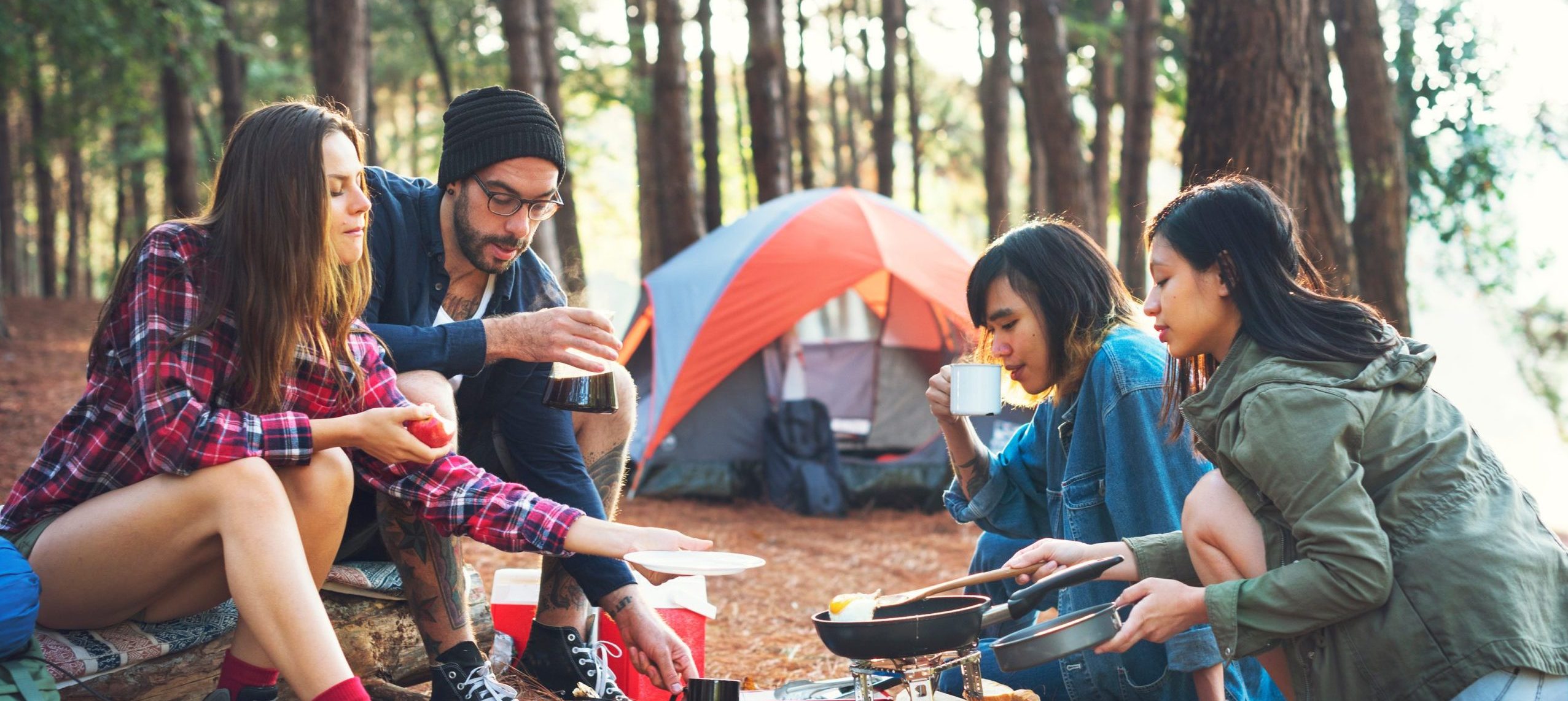 a group making food outside a tent on a campground