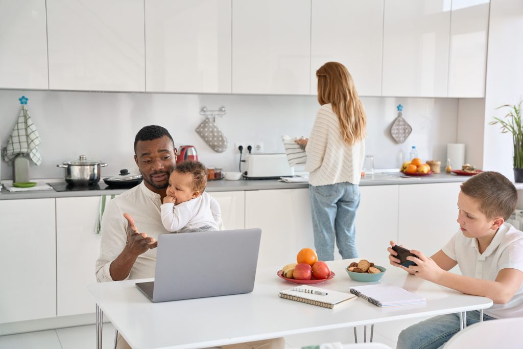 Family in the kitchen: dad, infant, pre-teen boy and mother