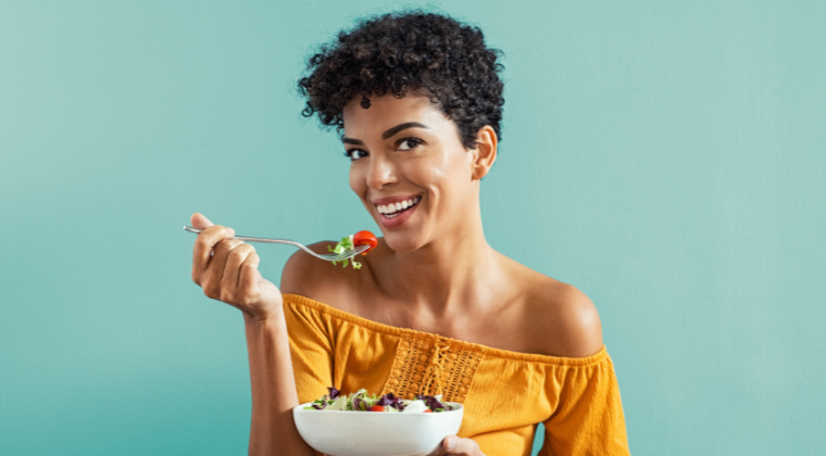 an image of a happy woman eating a healthy meal