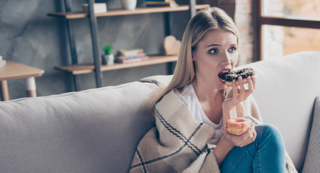 A woman sitting on the couch eating emotionally